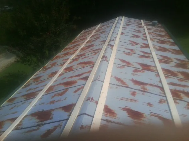 Rusted metal roof panels with new wood purlins before replacement — Storm Damage Roof Repair in Maple Lake by Roofing Brothers